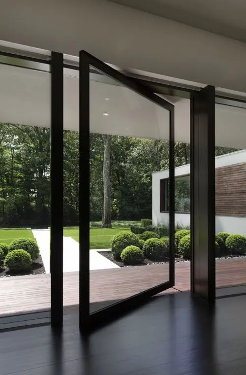 09 a glass wall with a pivot door makes an impression of having no boundaries with outdoors
