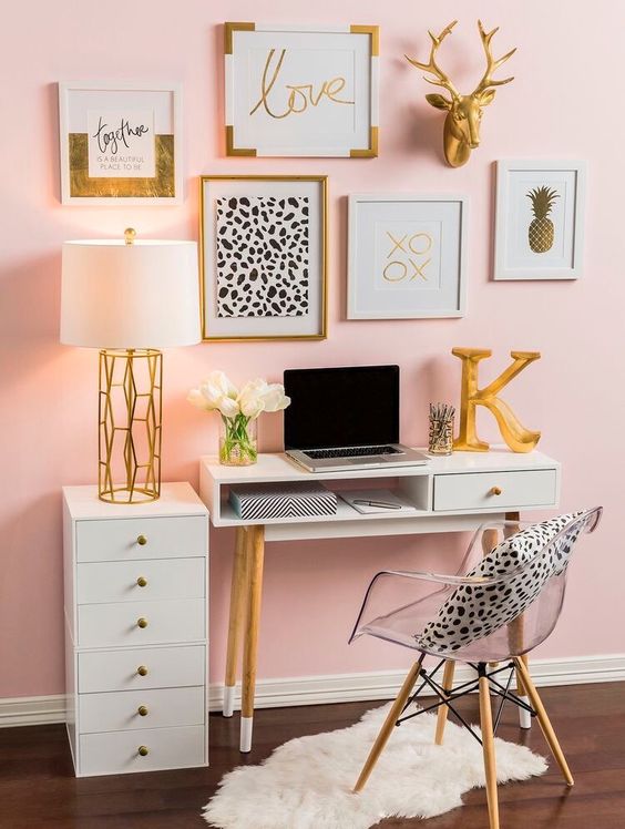 a glam home office with pink walls an acrylic chair a pretty gallery wall in gold black and white