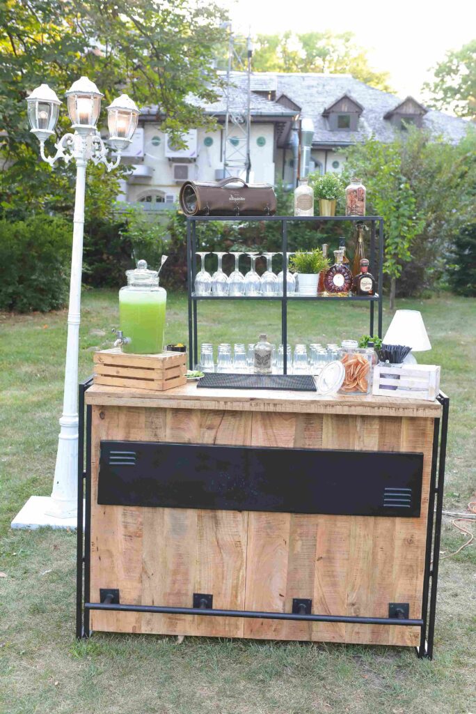 vertical shot wooden bar full glasses drinks lantern green garden 11zon